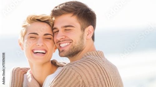 Portrait of laughing happy couple in love, around 30 years old, spending time together outdoors in park on sunny summer day. Affectionate boyfriend and girlfriend on picnic date. Lifestyle and romance