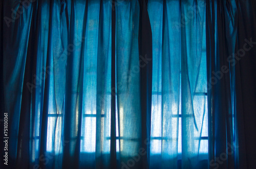 The transparent white curtain on the window.