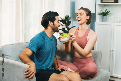 Healthy sporty and vegetarian couple in sportswear with a bowl of fruit and vegetable. Healthy cuisine nutrition and vegan lifestyle for fitness body physique at gaiety home concept.