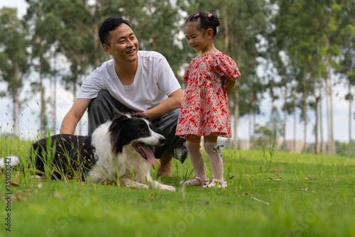 happy asian man with daughter and dog in the park photo