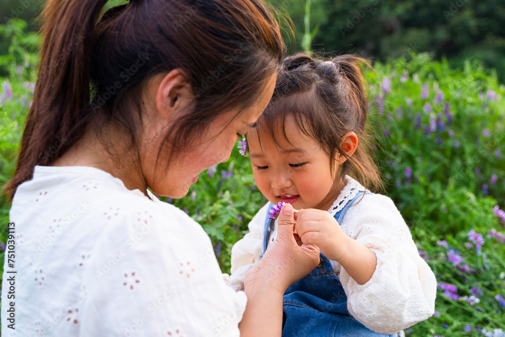 happy asian kid playing with her mother in the spring field happy asian kid playing with her mother in the spring field