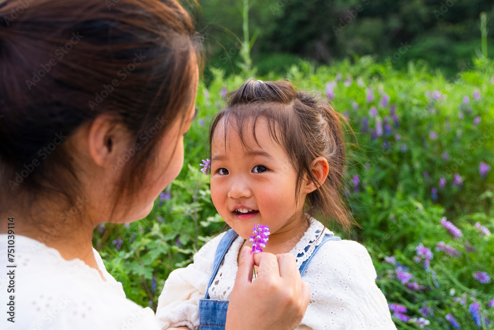 happy asian kid playing with her mother in the spring field happy asian kid playing with her mother in the spring field