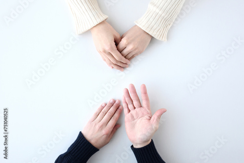 俯瞰で撮影された男女の話し合う手