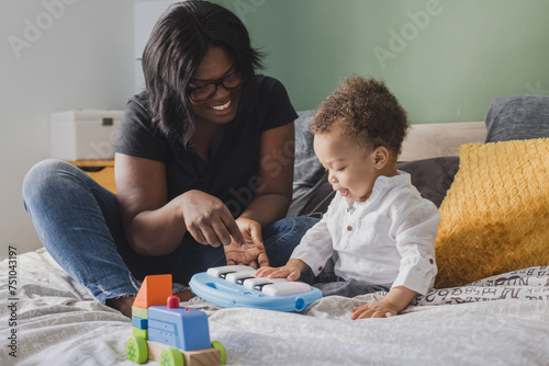 mother with small child playing with toys at home, small piano photo