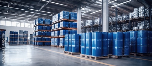 The image shows a vast warehouse space packed with rows of blue barrels stacked on pallets and multi-tiered racks holding boxes. The scene illustrates the storage and organization of goods in a photo