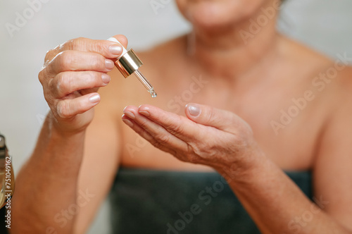 Woman applying serum  photo