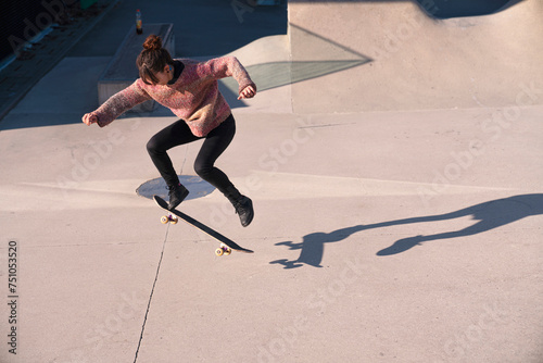 Beautiful young woman skateboarding in a skate park  photo