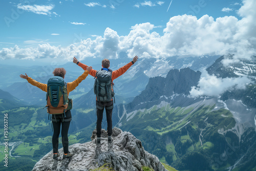 Two hikers raising their arms at the top of a hike