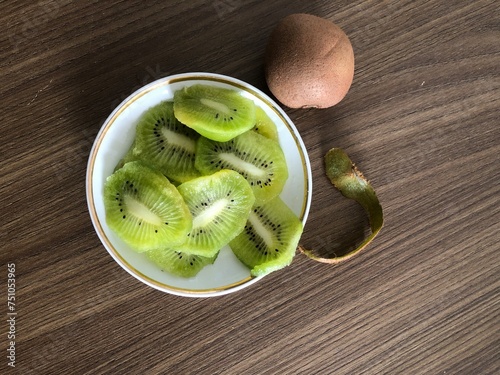 Fresh kiwi sliced on plate on a wooden background with copy space
​
 photo