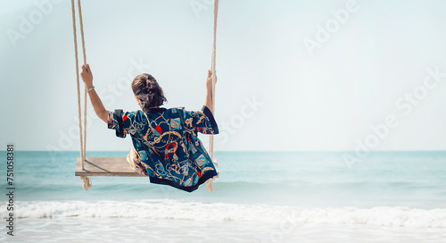 Traveler woman relaxing on swing above sea beach, summer holiday vacation trip © pornpun