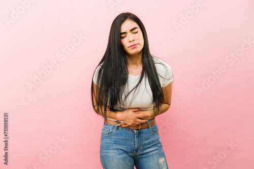 Sick young woman in pain because of cramps photo