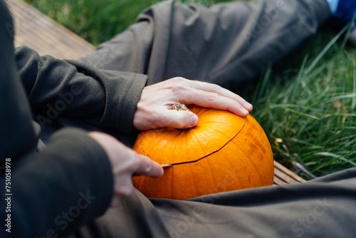 Man carving a pumpkin during Halloween photo