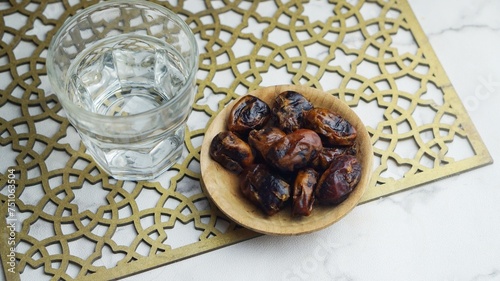 Kurma or dates fruit with glass of mineral water. Traditional Ramadan, iftar meal. Ramadan kareem fasting month concept