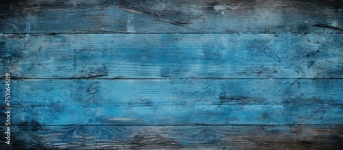 A blue grunge texture serves as a backdrop for an empty wooden table, while a black overlay adds contrast and depth to the composition.