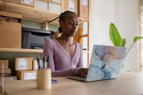 Black female logistic manager working on laptop photo