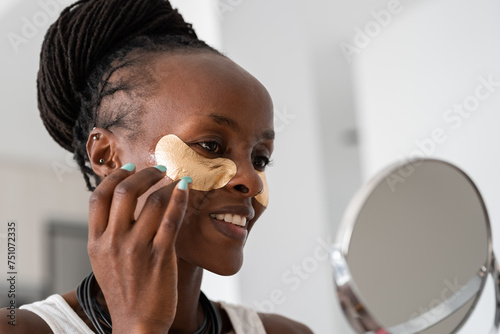 Content woman putting eye patches on face photo