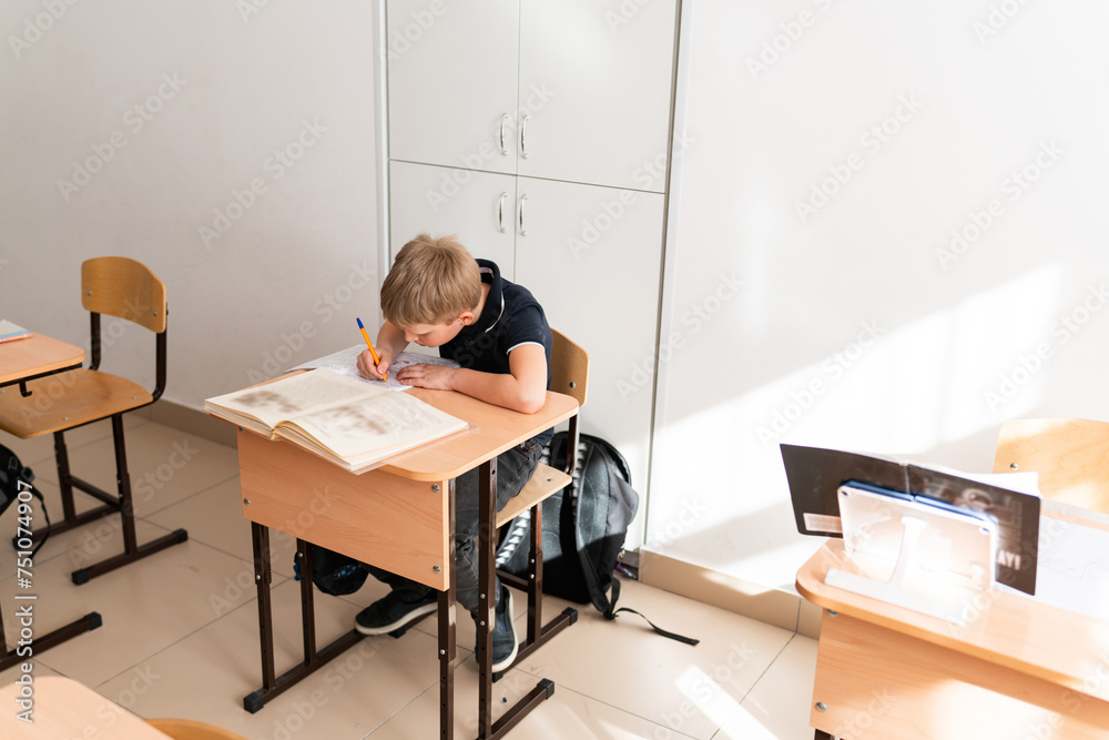 student at desk in light classroom student at desk in light classroom