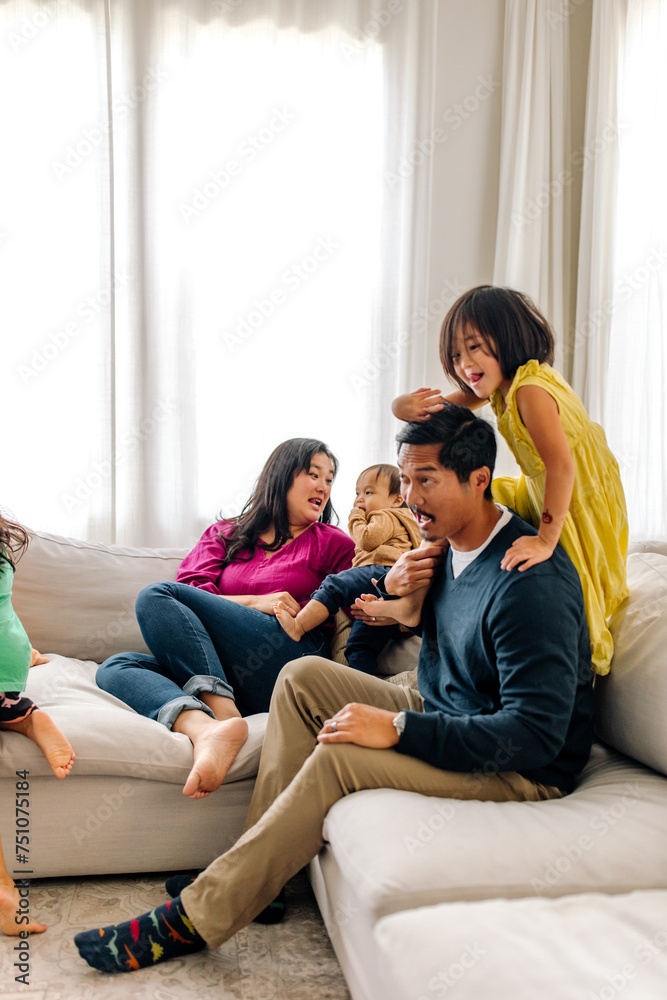 Family playing on couch at home Family playing on couch at home
