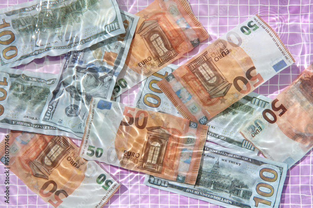 Euro and dollar bills underwater against pink pool tiles. Euro and dollar bills underwater against pink pool tiles.