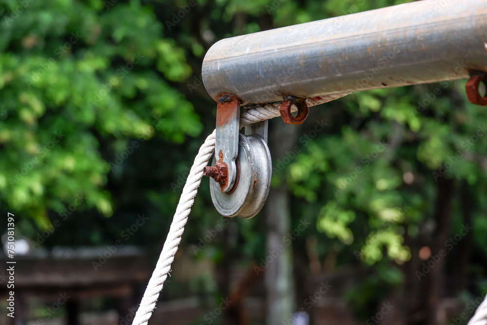 pulley hook dangling on beam pipe Rusty with rope in tree view pulley hook dangling on beam pipe Rusty with rope in tree view