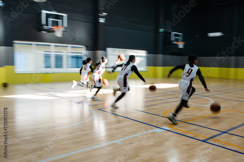 Basketball team playing in gym photo