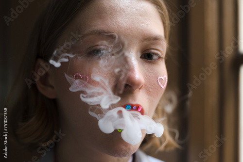 Woman with unconventional make up blowing smoke