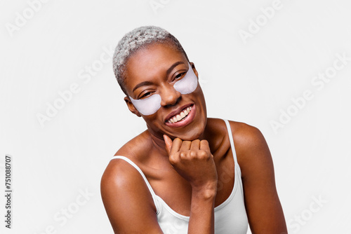 Portrait of a smiling woman with anti-wrinkle patches under her eyes. photo