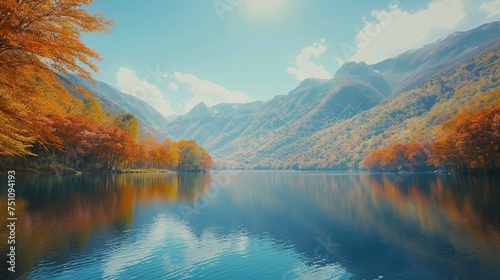 A serene lake surrounded by mountains, their slopes covered in trees displaying the full spectrum of autumn colors.