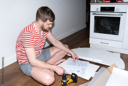 Wallpaper Mural Man reads the instruction while sitting on the floor of the house Torontodigital.ca