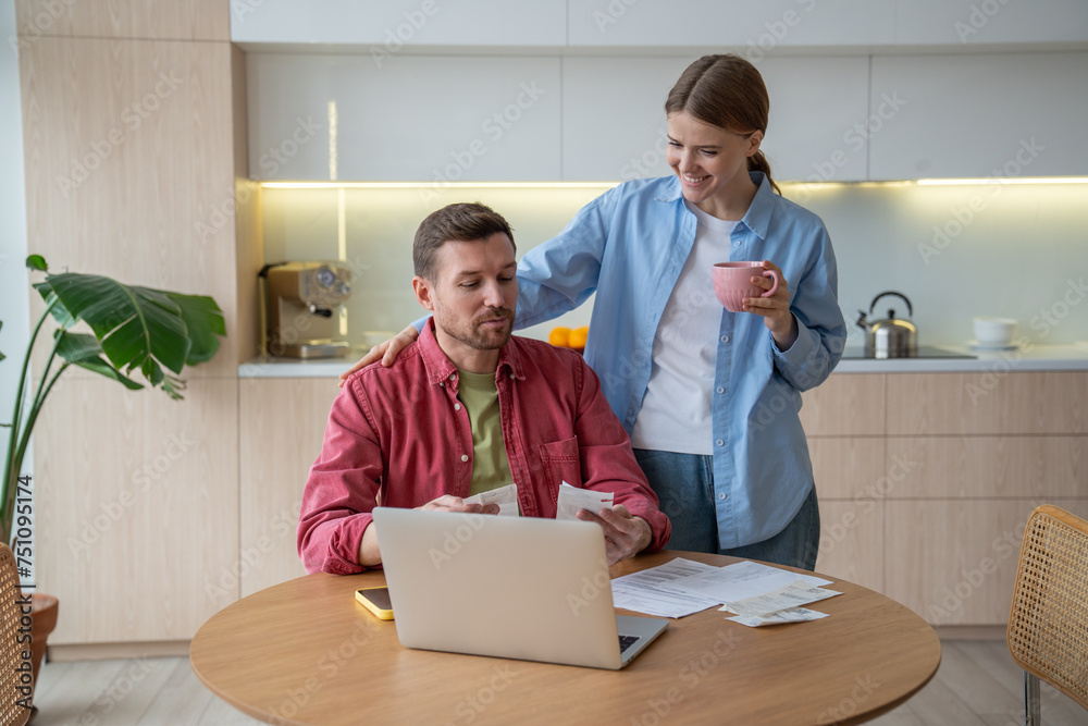 Husband boasts to wife about competent distribution family budget, correct calculation checks and documents. Monthly routine of paying family bills brings joy satisfaction to successful married couple Husband boasts to wife about competent distribution family budget, correct calculation checks and documents. Monthly routine of paying family bills brings joy satisfaction to successful married couple