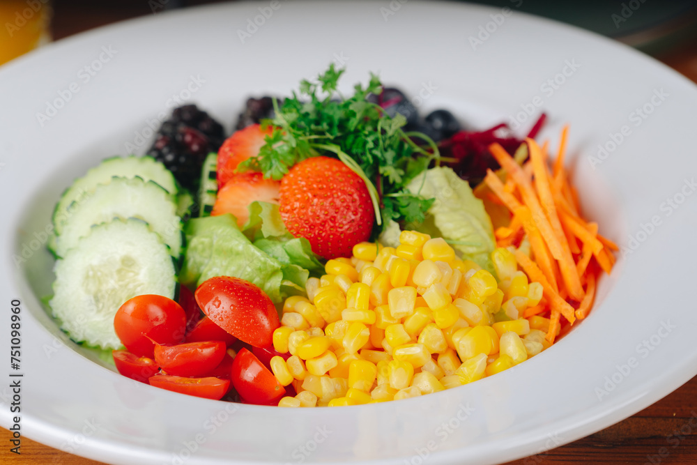 A colorful salad with a variety of vegetables and fruits, including tomatoes A colorful salad with a variety of vegetables and fruits, including tomatoes