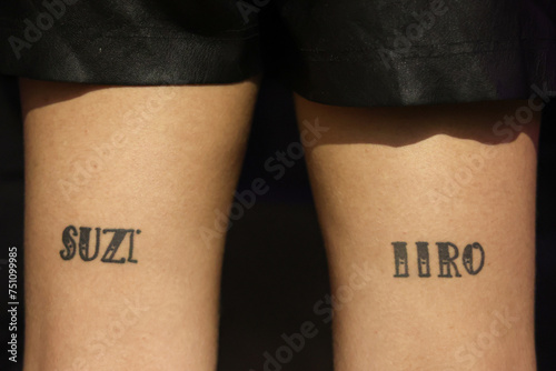 Tattoo of names on the back of a woman's tights photo