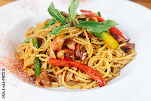 A plate of noodles with meat and vegetables