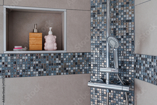 Nice modern bathroom with gray tiling walls and mosaic, shower and shelve