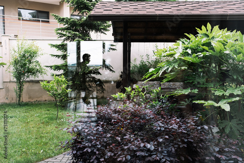 The reflection of a person through the window into the courtyard.