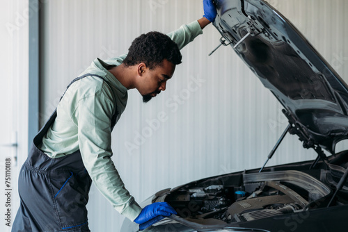 Mechanic Repairing Car in Garage photo