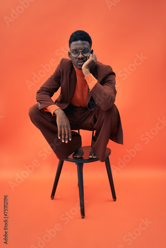 Black male model strangely posing on a chair