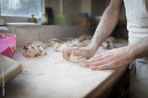 hands knead a loaf of bread