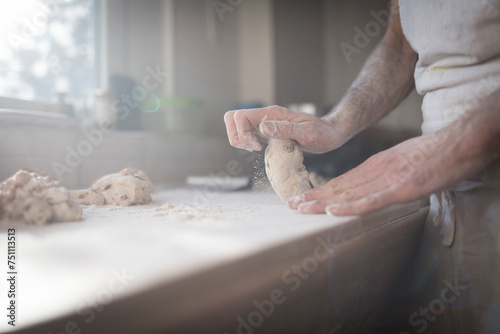 hands knead a loaf of bread photo