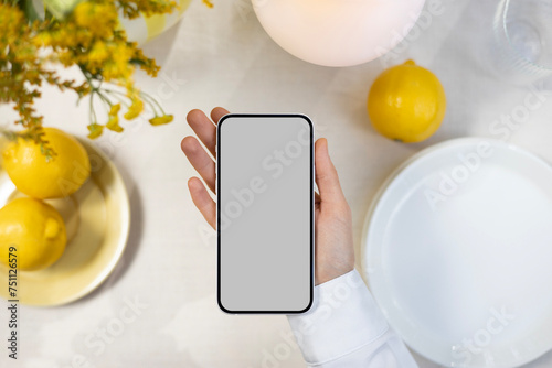 Phone mockup with blank screen on summer dinner table background.  photo