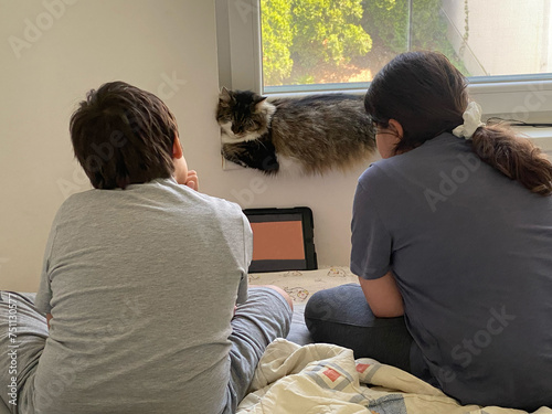 Two friends and a cat watching videos on tablet  photo