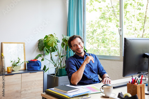 Content male accountant smiling during remote work photo