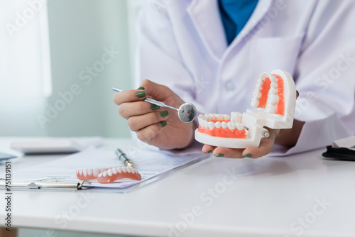 oral dentistry Female dentist in machine talking with male patient on table in clinic, dental model, dental health care according to prescription