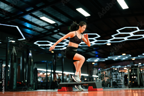 Fototapeta Naklejka Na Ścianę i Meble -  Young Sportive Woman Workout Exercising with Step Platform at Fitness Center or Gym. Fitness and Wellness Concept