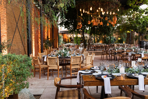 A wedding setup with wooden tables and chairs in a venue photo