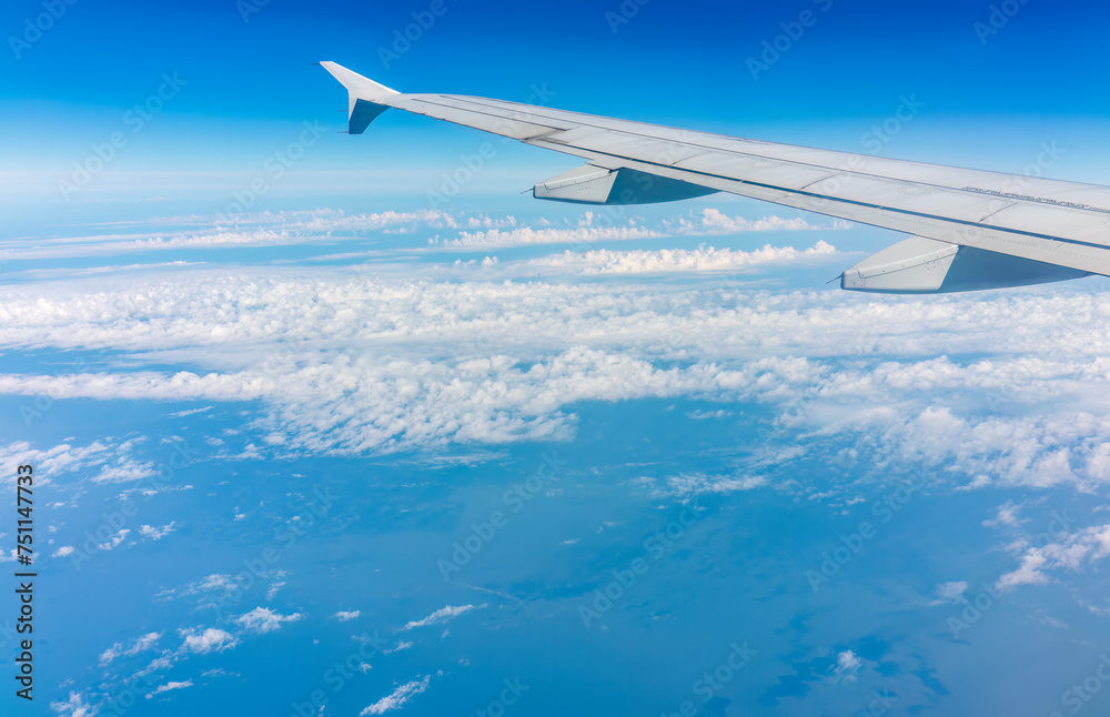 View from the airplane window at a beautiful cloudy sky and the airplane wing