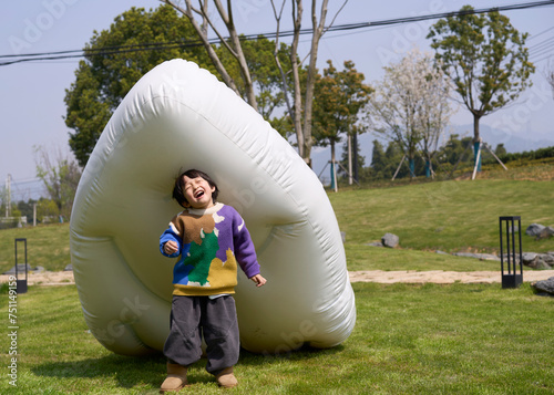 Asian boy playing with inflatable mattress outdoors photo