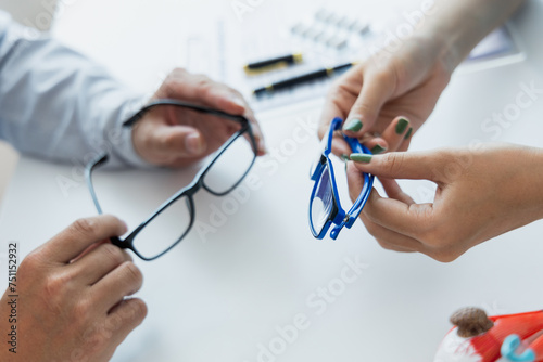 Female doctor talking with patient in clinic room at table Focusing on eye health with male patients. and use eye models and eyeglasses to discuss vision health.