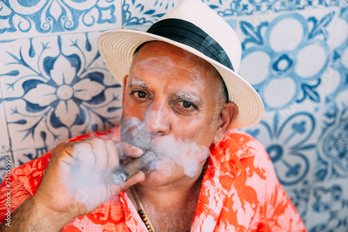 Senior cuban man in tropical outfit smoking a cigar