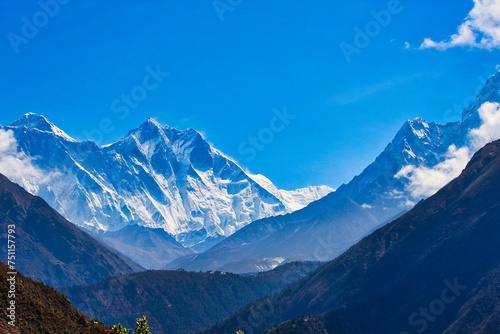 Beautiful image of the Everest Massif set against a blue sky behind deep valleys during the Everest Base camp trek near Namche Bazaar, Nepal